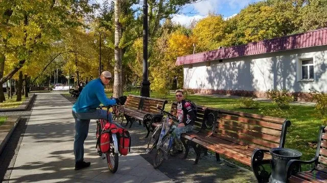 Велосипедисты отдыхают на парковых скамейках