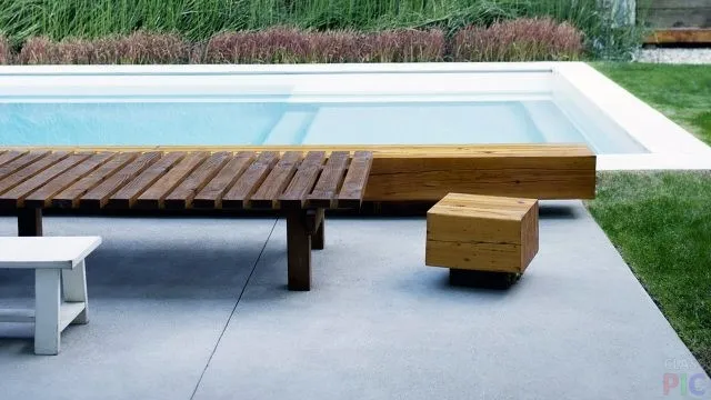 Деревянные скамейки у бассейна в саду