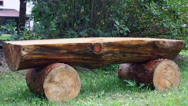 Деревенская лавка из брёвен стоит под вишней