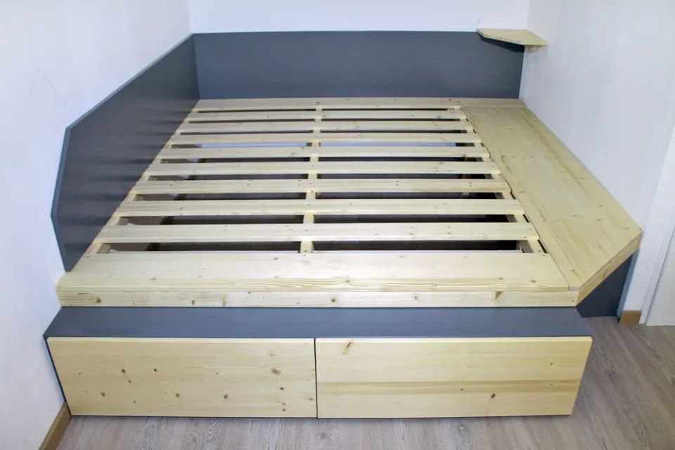 Самодельная кровать с выкатными ящиками встроена в нишу, благодаря чему спальню можно устроить даже в очень небольшой комнате